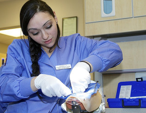 Dental assistant practicing on dummy